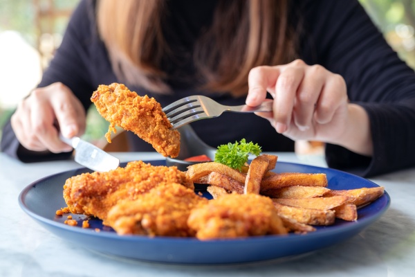 Woman eating fried food Woman eating fried food